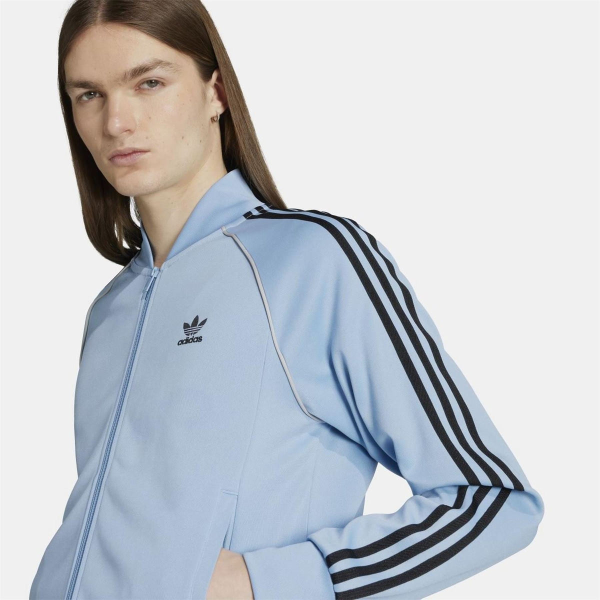 adidas Originals Classic SST track jacket in navy with white stripes, made of comfortable polyester fabric.