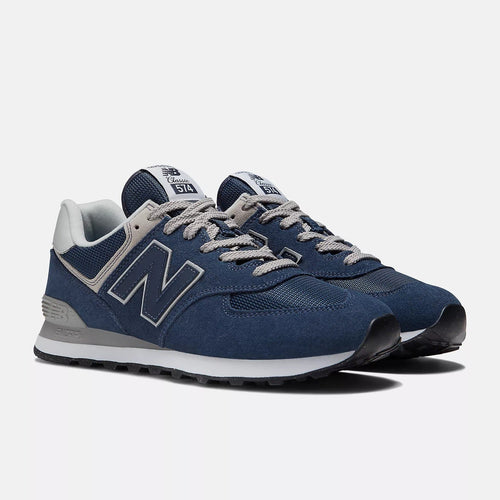 New Balance 574 sneakers, navy blue with white accents and lace-up front, angled